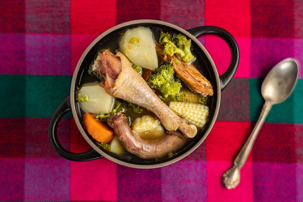 Overhead shot of Honduran chicken soup on a multicolored surface